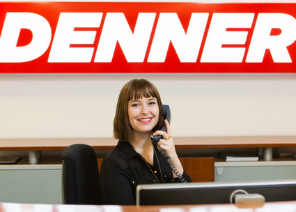 Lächelnde Frau in der Verwaltung am Telefon Una collaboratrice al telefono